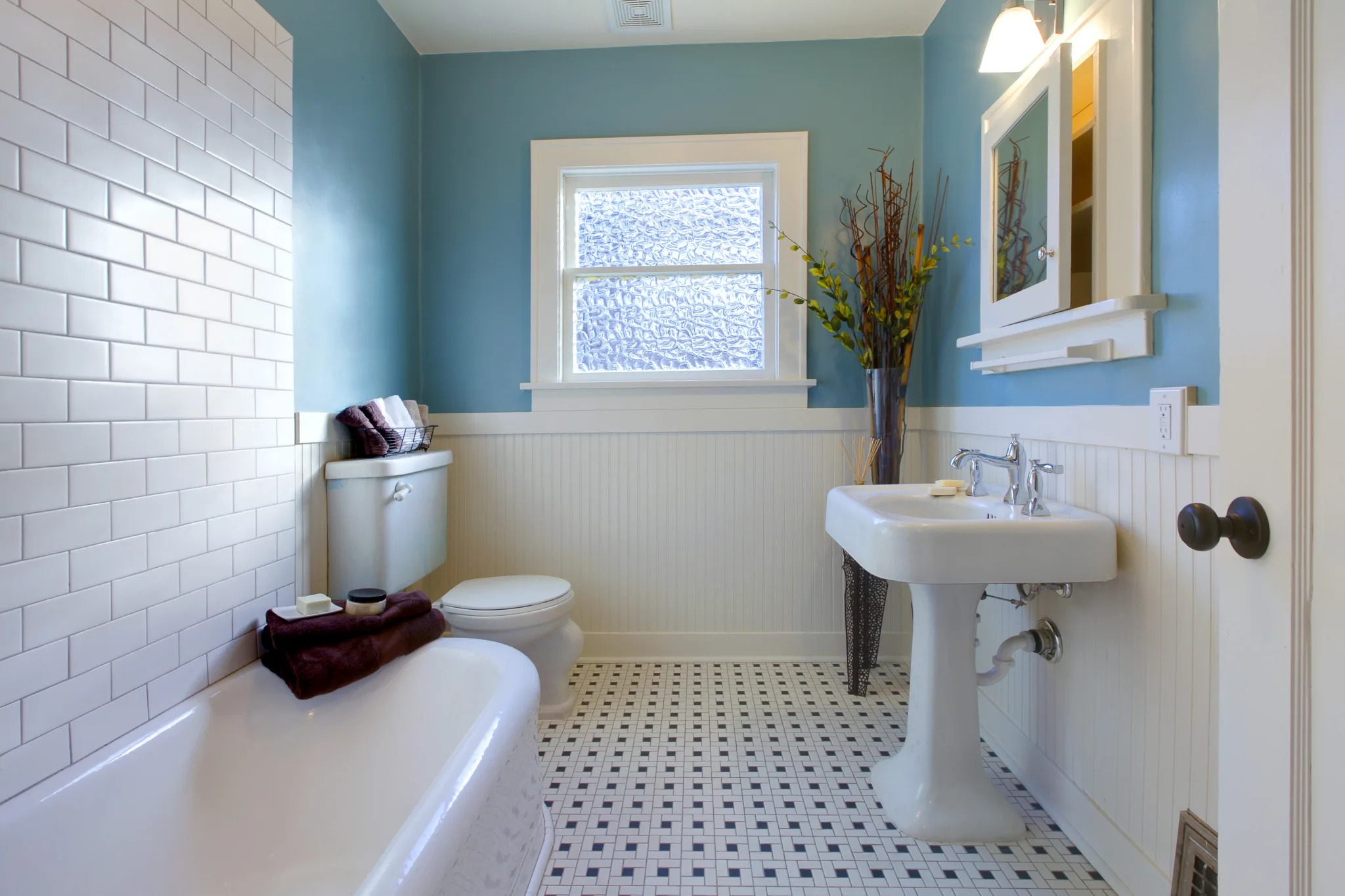 Traditional bathroom, with blue painted walls and tiled floor.